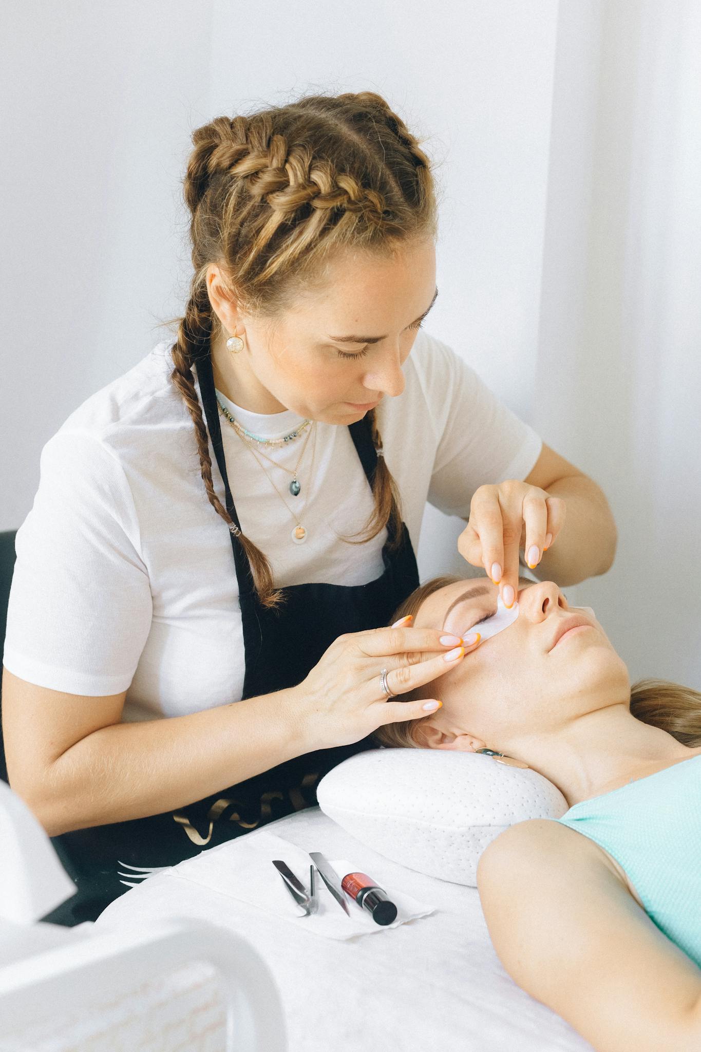 Beauty therapist applies eye treatment in spa setting. Relaxation and professionalism in focus.